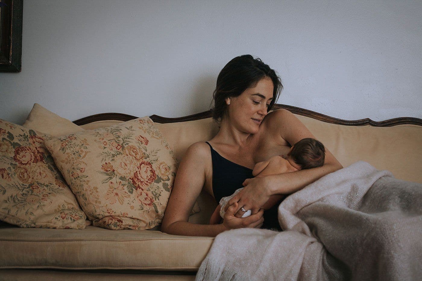 Mom breastfeeding baby in her arms on couch