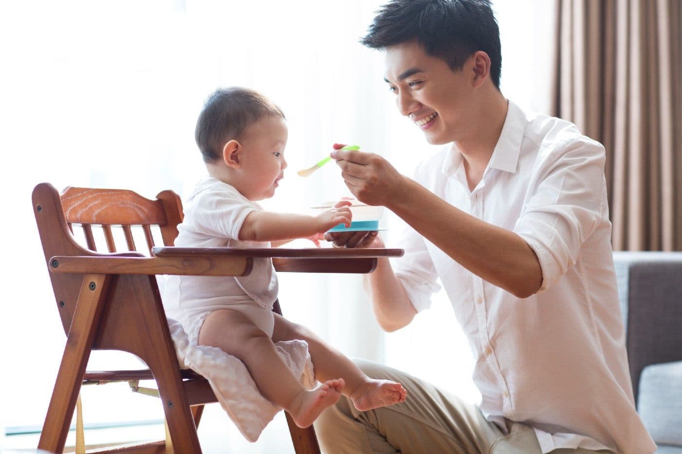 Dad feeding baby proteins